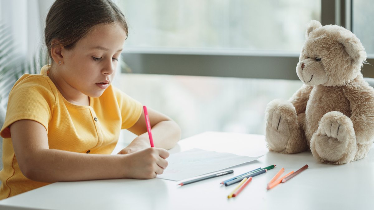 Élève concentrée à son bureau : les aménagements scolaires TDAH (PAP, PPS, AESH) l'aident à suivre en classe