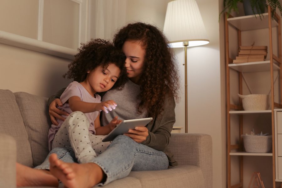 Parent qui aide son enfant à cocher ses consignes : le contrat de comportement suivi au quotidien