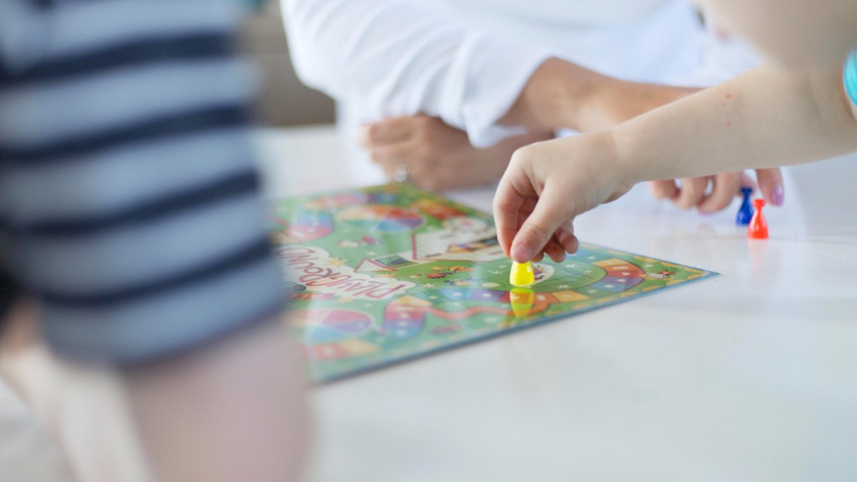 Enfant concentré sur un jeu de plateau : un bilan neuropsychologique évalue notamment l'attention