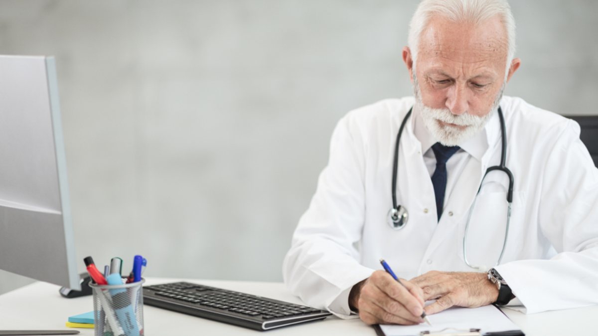 Médecin qui rédige à son bureau : le parcours du diagnostic TDAH chez l'enfant