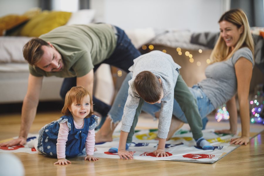 Famille qui joue ensemble au sol du salon, un moment sans écran avec les enfants