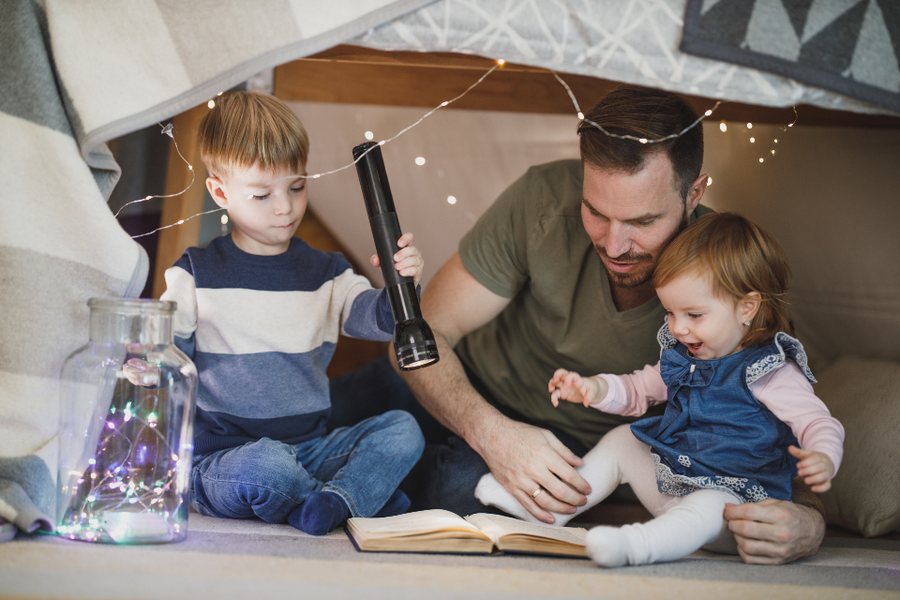 Enfant absorbé par un livre avec son père, un des signes possibles d'un enfant HPI