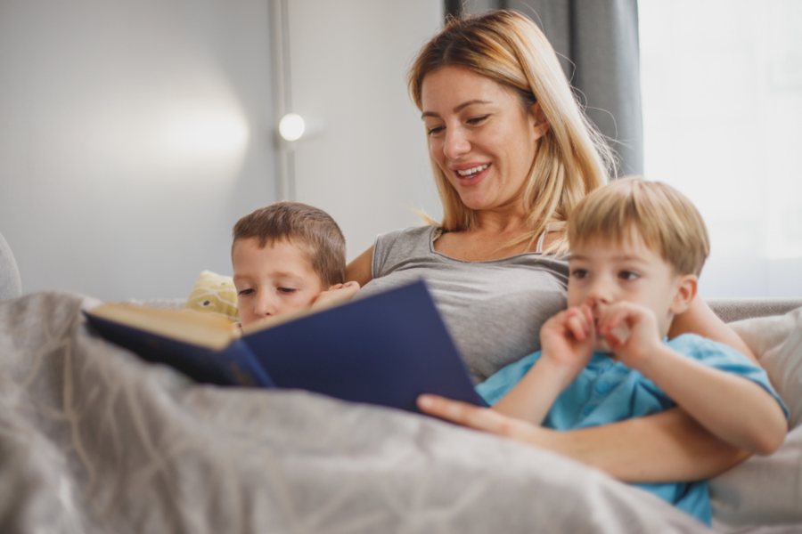 Mère qui lit un livre avec ses deux garçons : la hausse des diagnostics TDAH vue du côté des familles