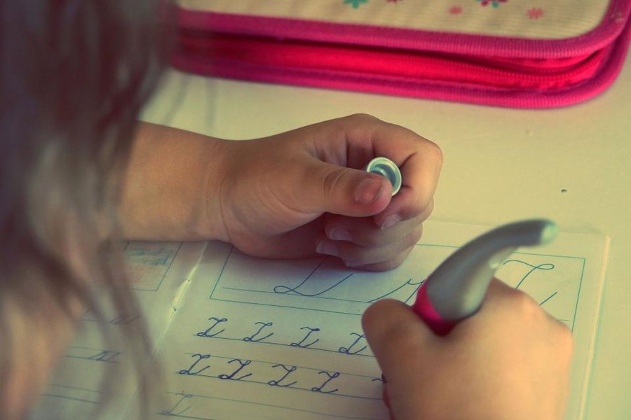 Enfant qui fait ses devoirs d'écriture, une étape souvent difficile pour un enfant HPI et TDAH
