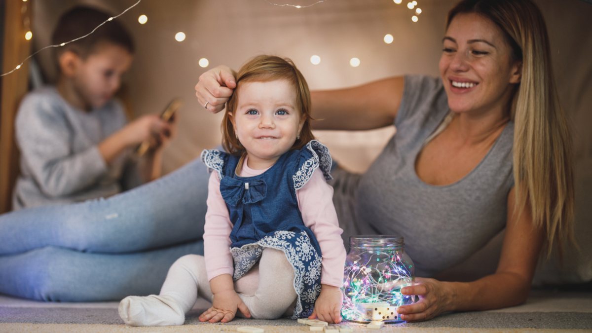 Mère qui joue avec ses enfants à la maison, un moment propice au renforcement positif