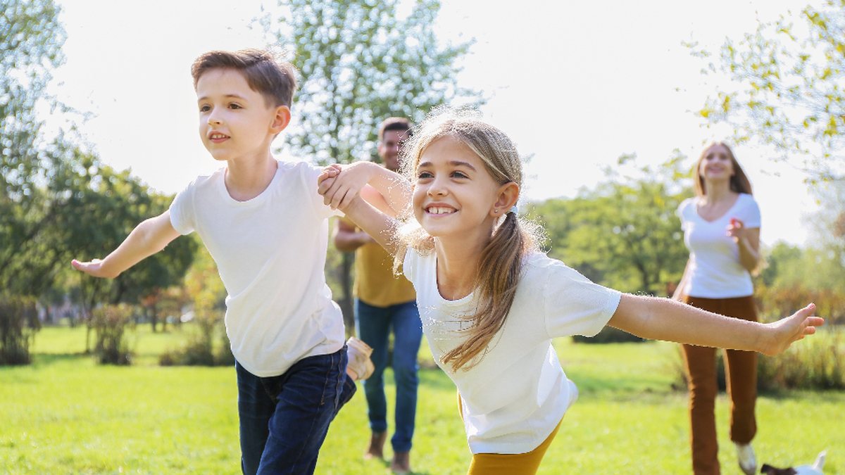 Enfants qui courent dans un parc : l'agitation fait partie des signes du TDAH chez l'enfant à observer