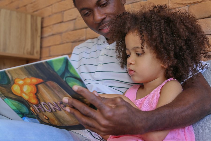 Père et fille lisant un livre ensemble : observer au calme les signes du TDAH chez une fille