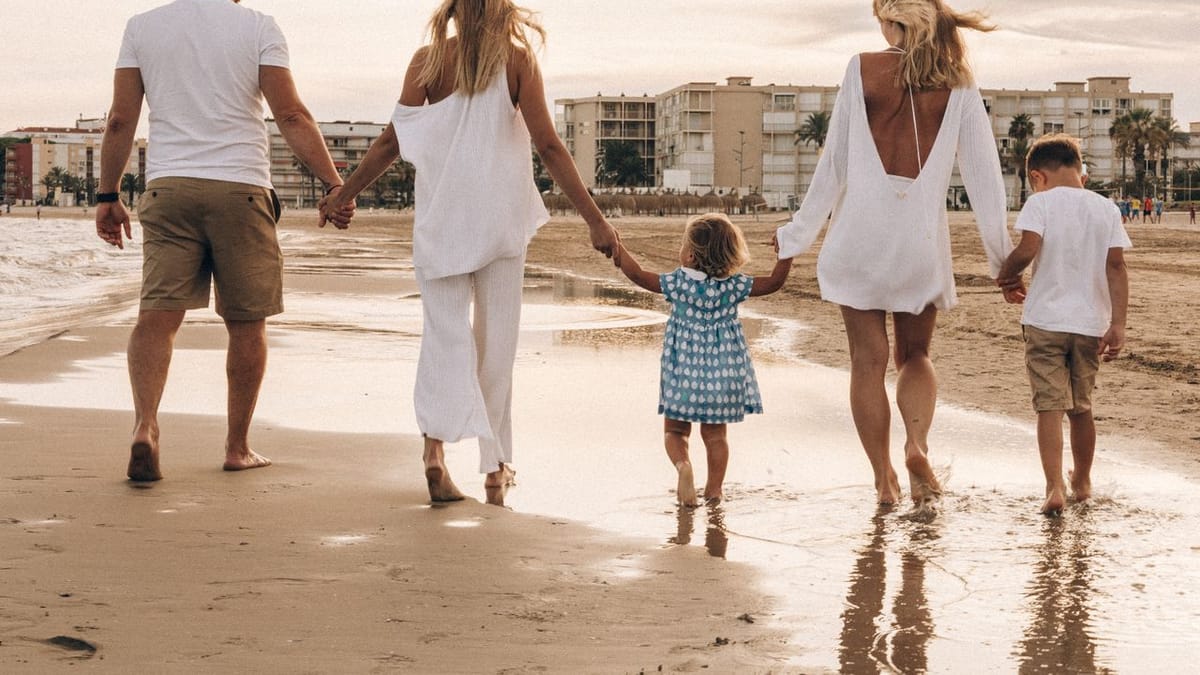 Famille unie marchant main dans la main sur la plage